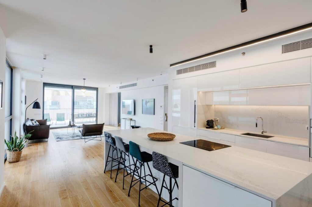 Elegant open-plan living room in Tel Aviv luxury apartment at Renoma, with natural light and modern décor