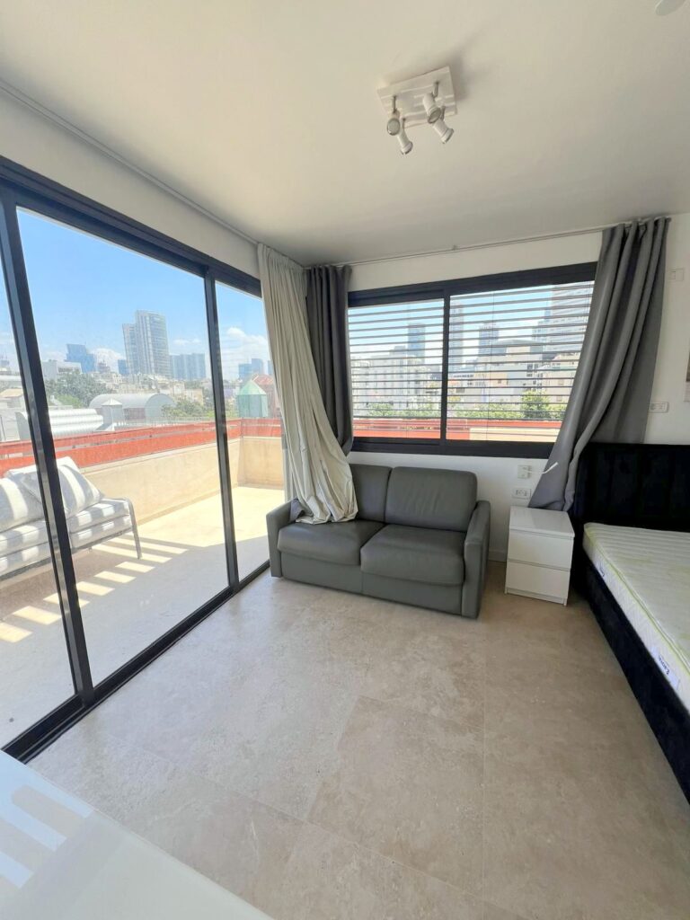 Stylish penthouse dining and kitchen area with glass doors to balcony