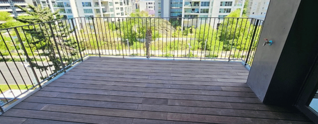 Balcony with wooden decking and view of green urban surroundings