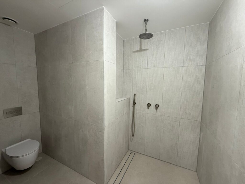 Minimalist luxury bathroom with walk-in rain shower and modern tiling