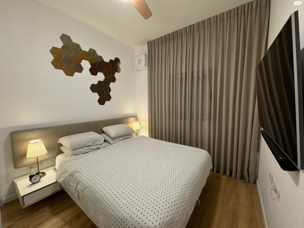 Stylishly designed bedroom with built-in storage in Tel Aviv apartment