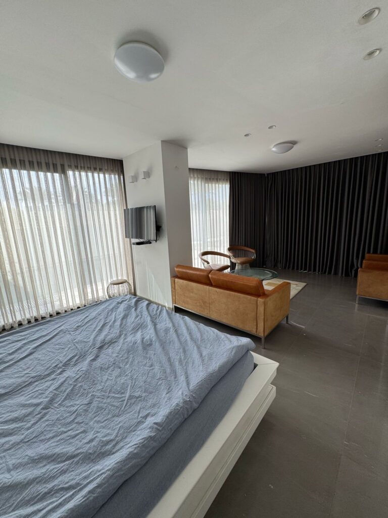 Elegant bedroom with lounge space and natural light in Tel Aviv