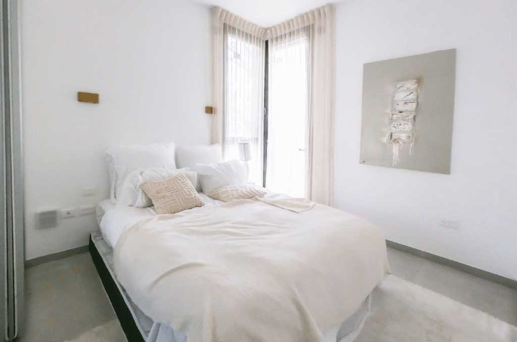 Minimalist modern bedroom with light tones and large windows
