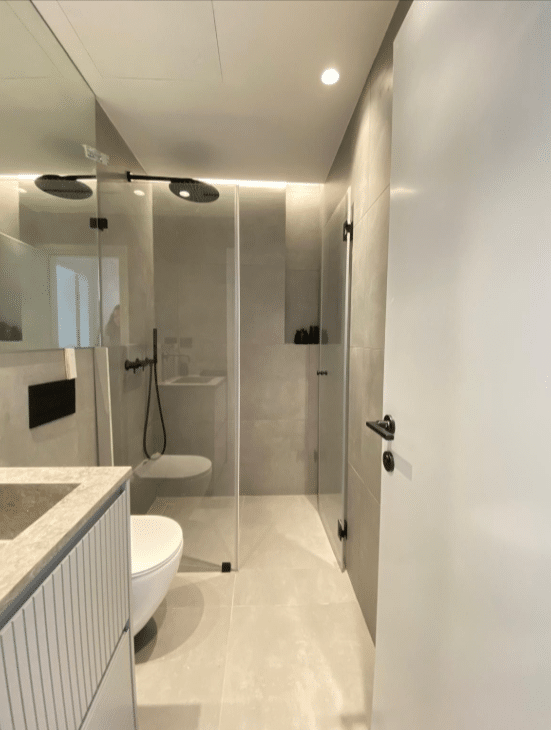 Stylish bathroom with glass shower in Tel Aviv apartment