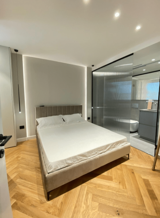 Elegant bedroom with glass divider and modern decor in Tel Aviv apartment