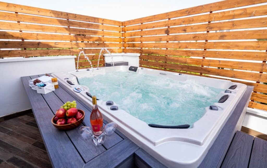Private outdoor terrace with jacuzzi and wooden fencing