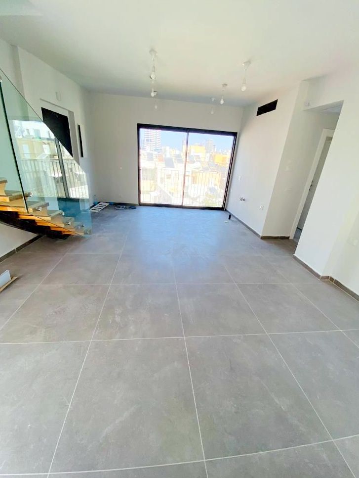 Open space in Tel Aviv duplex with glass staircase