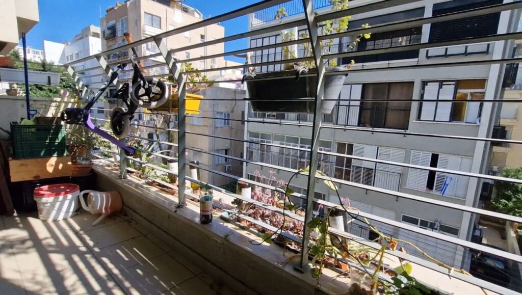 Balcony with planters and view of Tel Aviv buildings