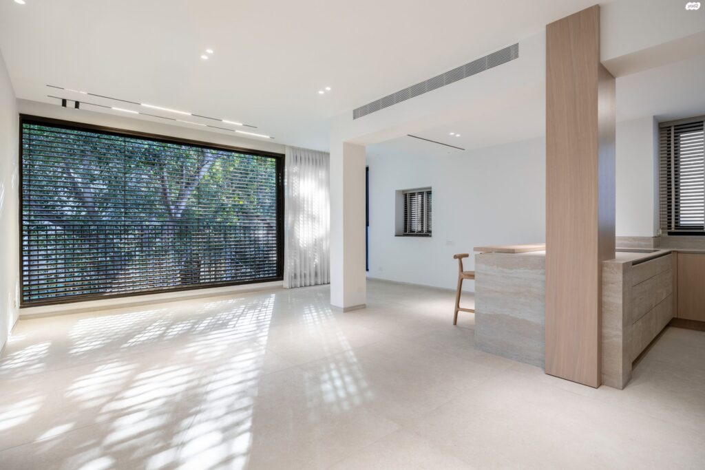 Bright living room with large windows and custom finishes in Tel Aviv apartment