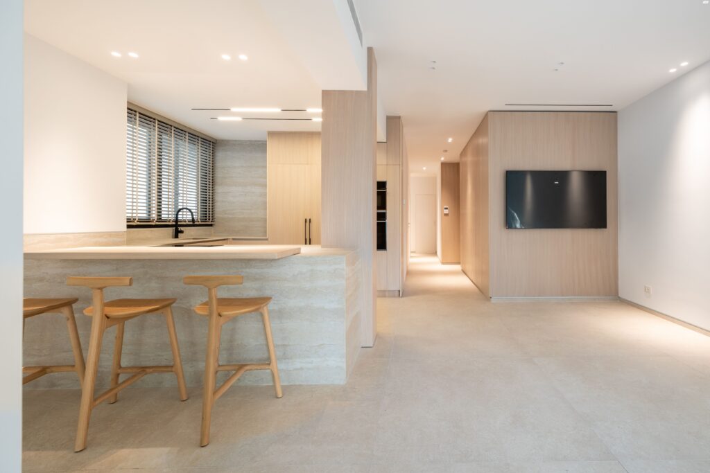 Open-concept kitchen with oak finishes and bar seating in north Tel Aviv apartment