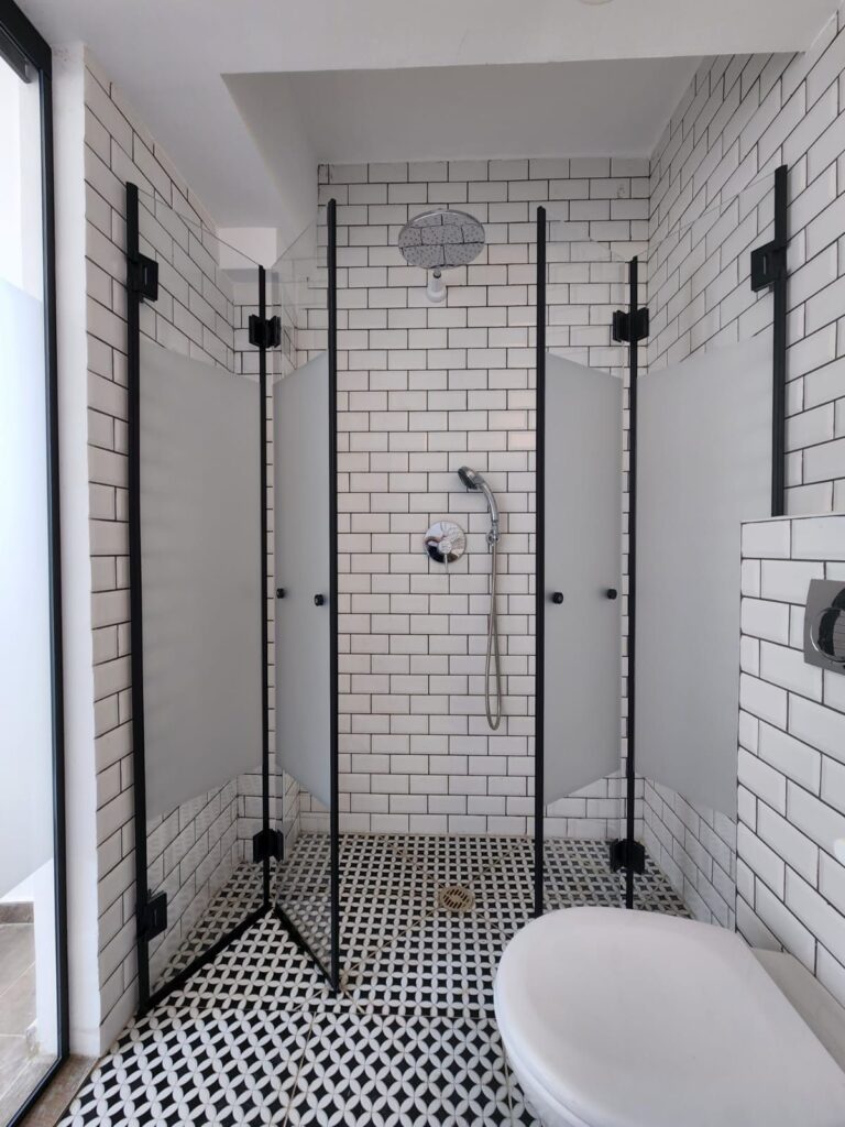 Stylish tiled bathroom with black accents and glass shower