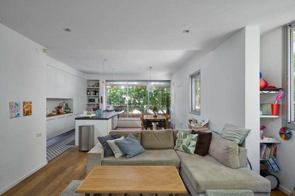 Open-plan living space with modern kitchen and large windows – Tel Aviv apartment