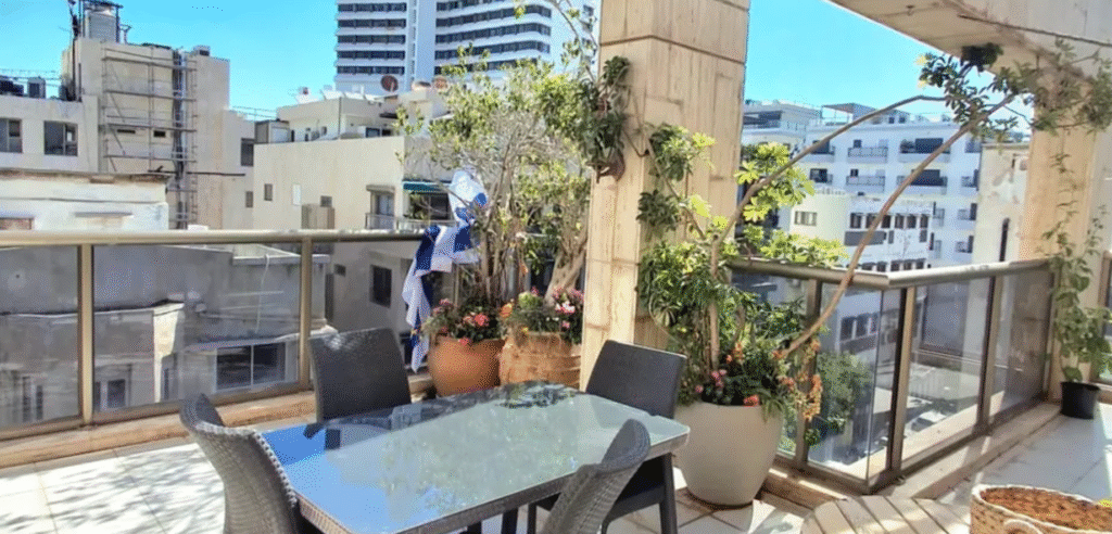 Balcony with dining area and plants in Tel Aviv apartment