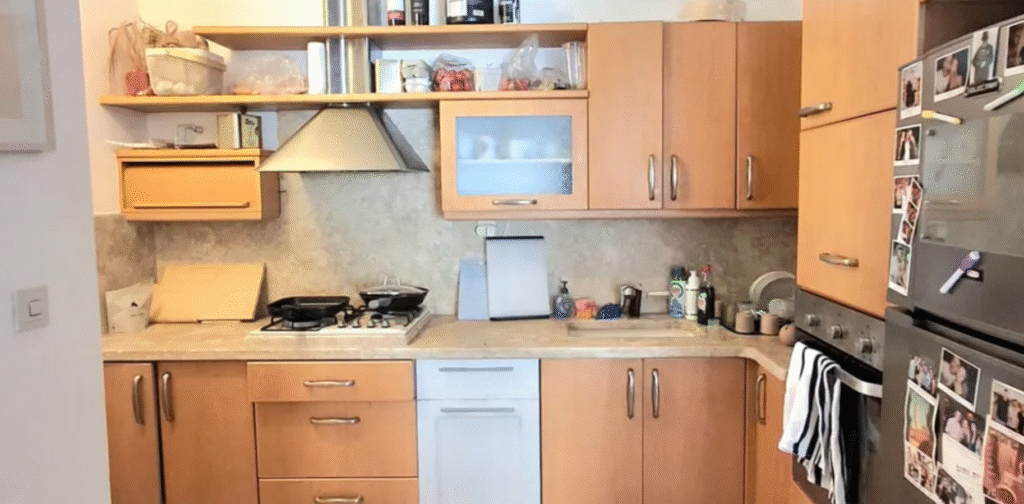 Fully equipped kitchen with wooden cabinets in Tel Aviv apartment