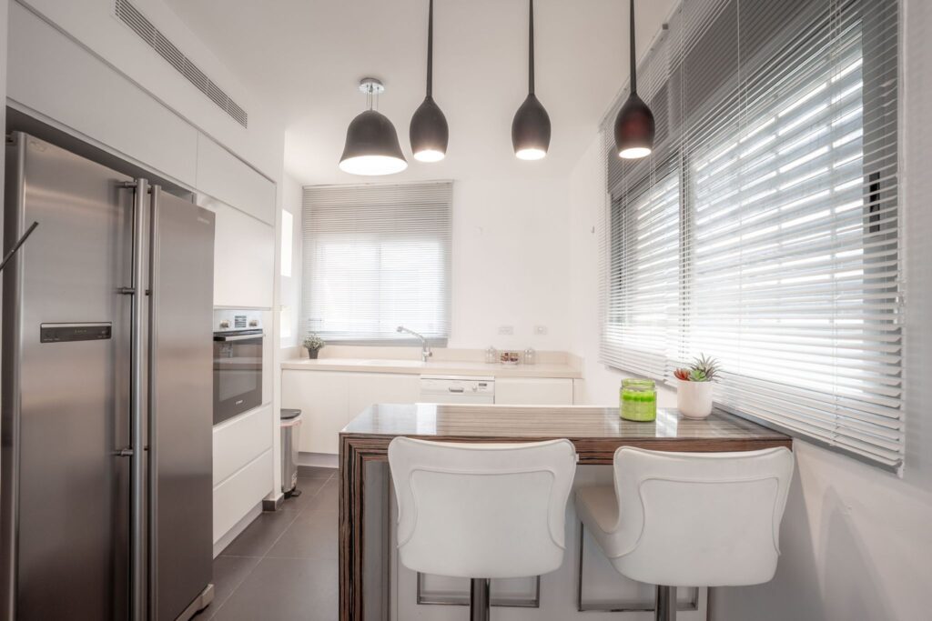 Modern kitchen with island and pendant lighting in Tel Aviv apartment
