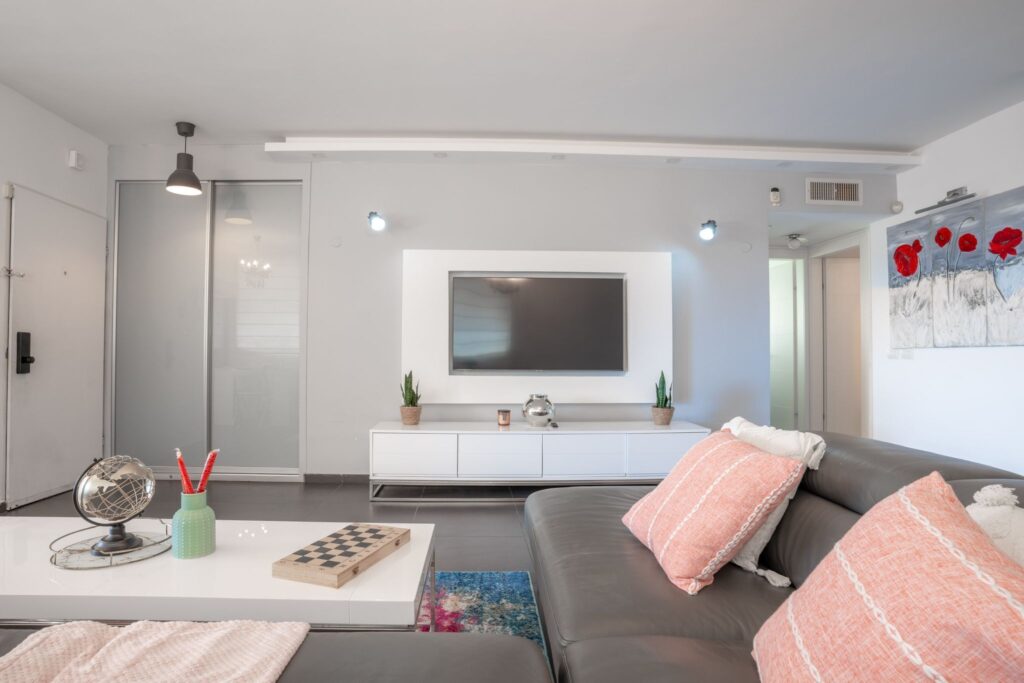 Stylish living area with TV and accent decor in Hayarkon apartment
