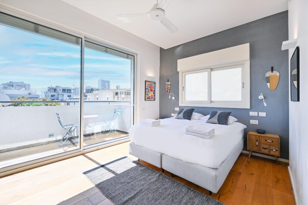 Master bedroom with private balcony and skyline views in Tel Aviv