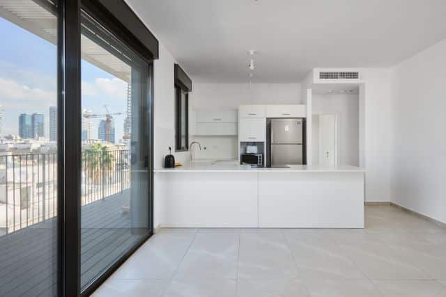 Modern white kitchen and balcony with skyline views – Tel Aviv