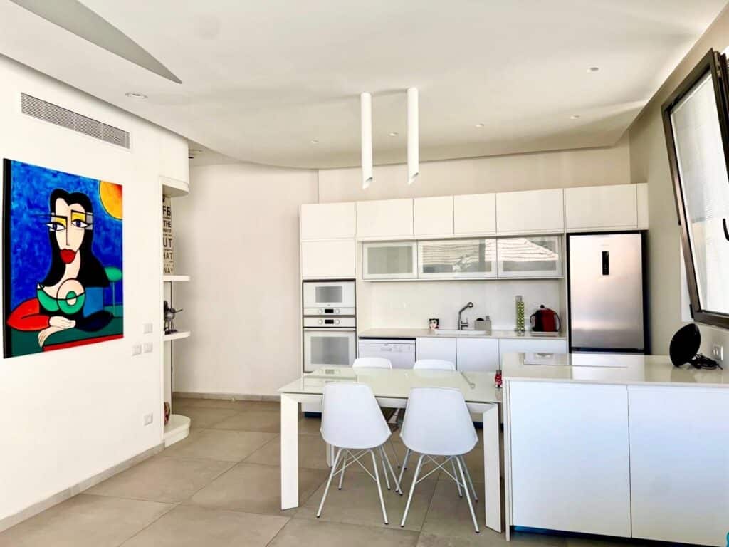 Bright modern kitchen with dining area in Tel Aviv apartment