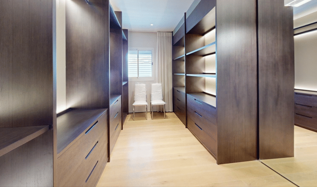 Spacious walk-in closet with dark wood cabinetry in Tel Aviv penthouse