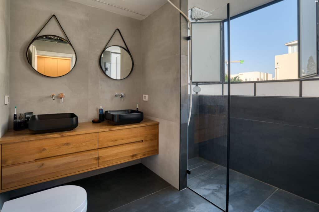 Modern Tel Aviv apartment bathroom with dual sinks and walk-in shower