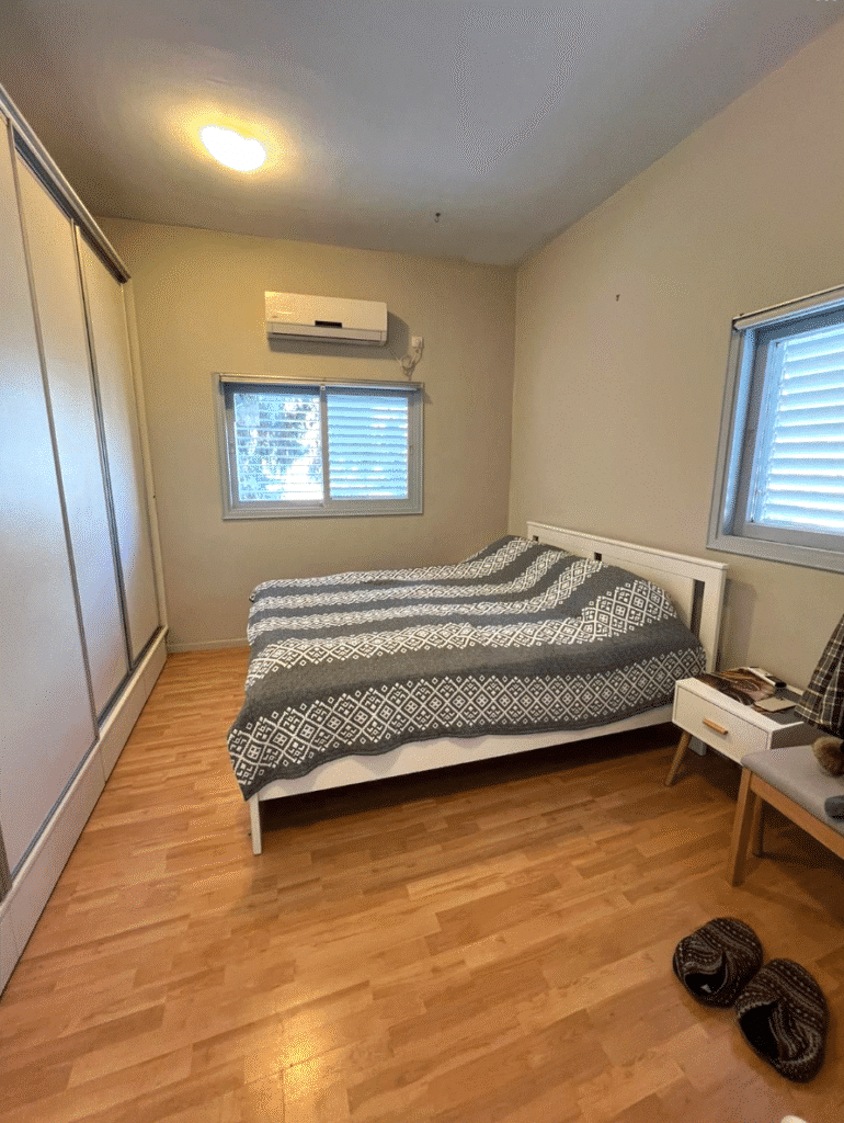 Renovated bedroom with parquet flooring and double windows in Tel Aviv apartment