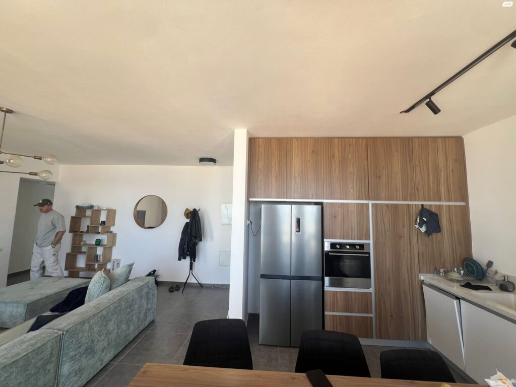 Modern kitchen with wood finish in furnished Tel Aviv apartment