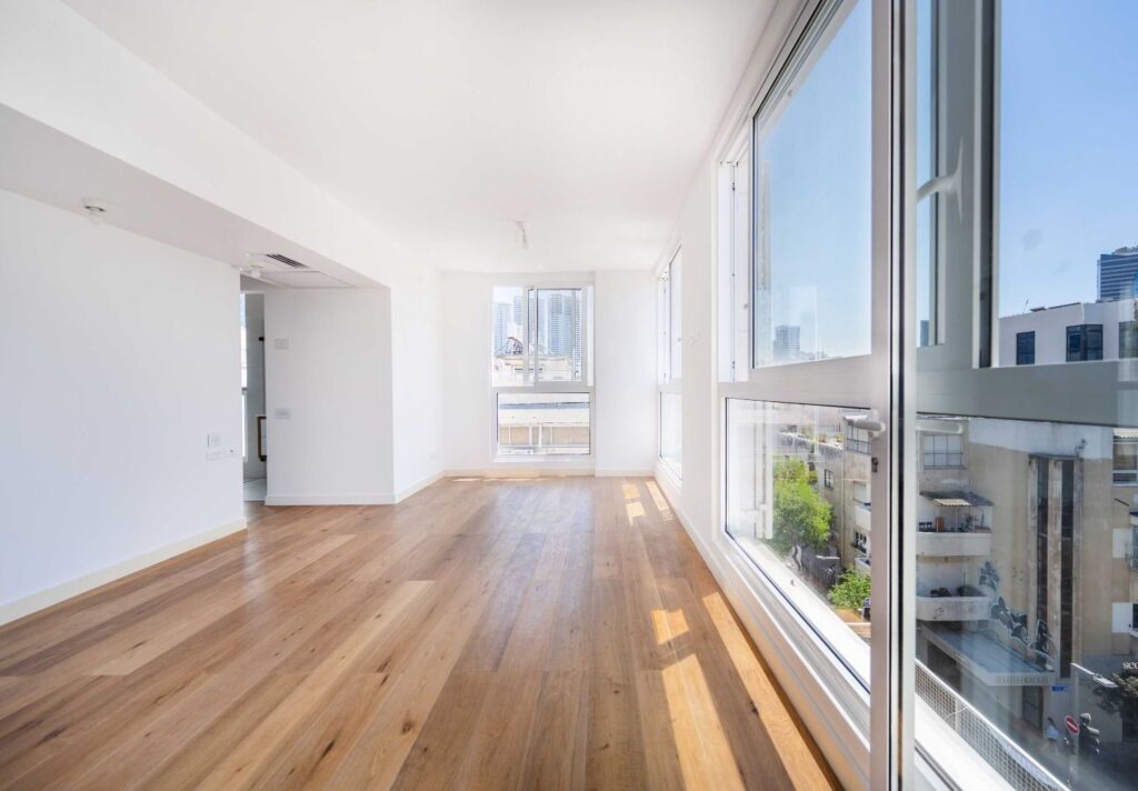 Sunlit living area with panoramic windows and wood flooring
