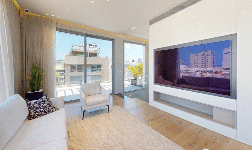 Elegant living room with large TV and balcony view in Tel Aviv