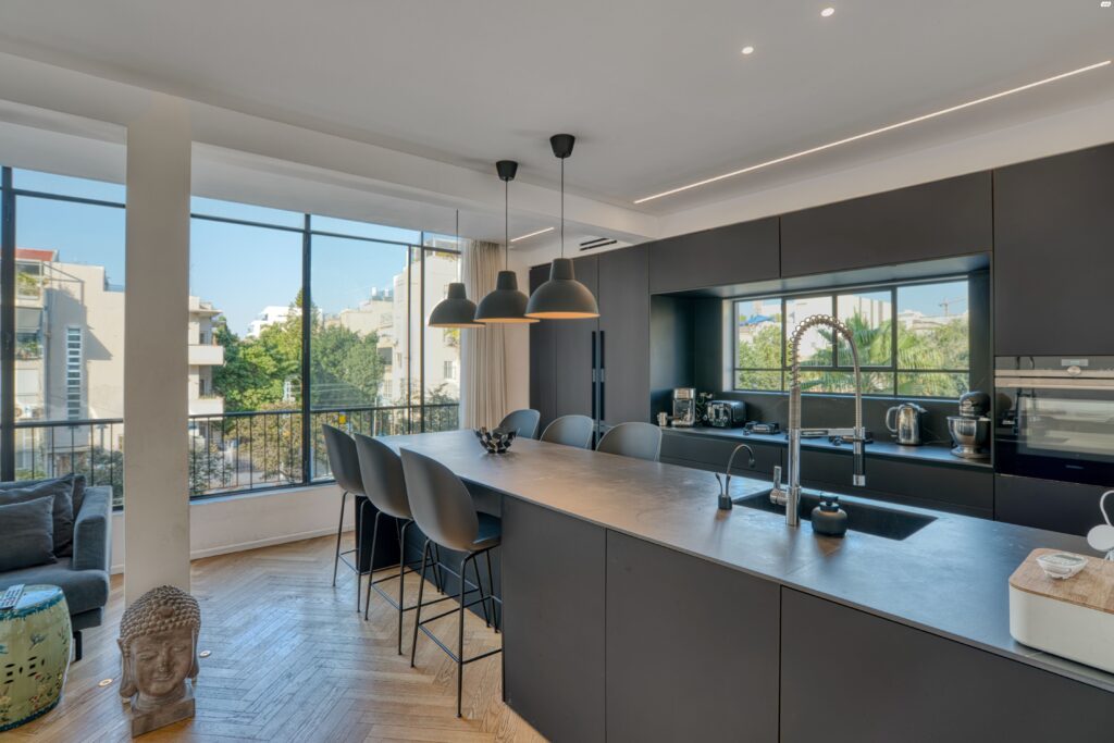 Contemporary black kitchen with island in Tel Aviv apartment