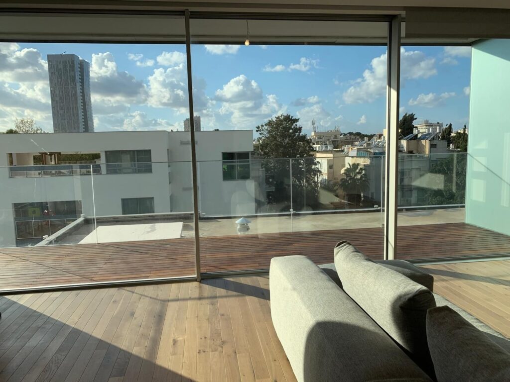 Balcony with glass railing and open view in Tel Aviv luxury apartment