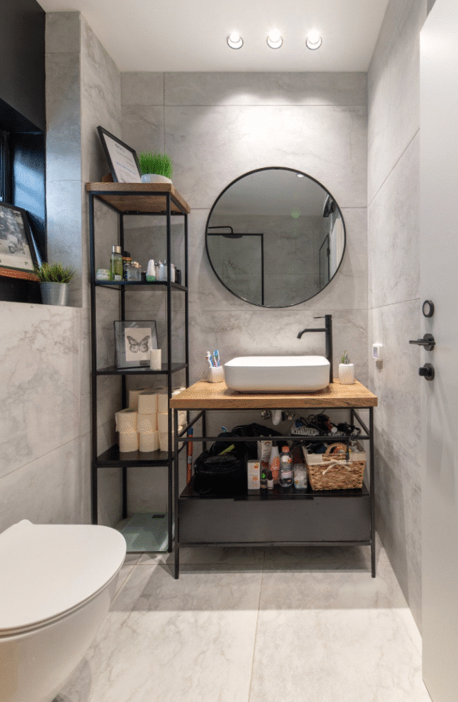 Contemporary bathroom with minimalist design and round mirror in renovated Tel Aviv flat