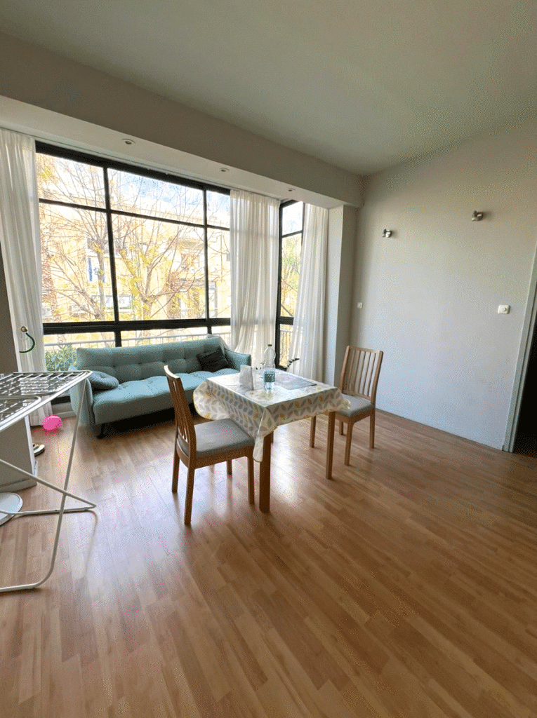 Sunny living room with dining area and large windows in Tel Aviv flat