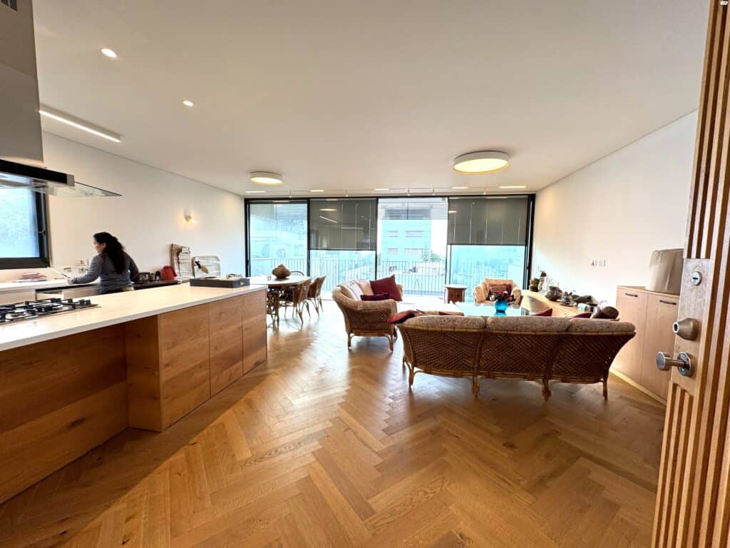 View from kitchen to dining and living areas in modern Tel Aviv apartment