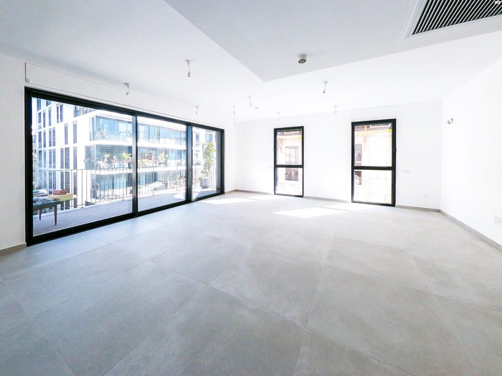 Bright and expansive living room with large windows in central Tel Aviv