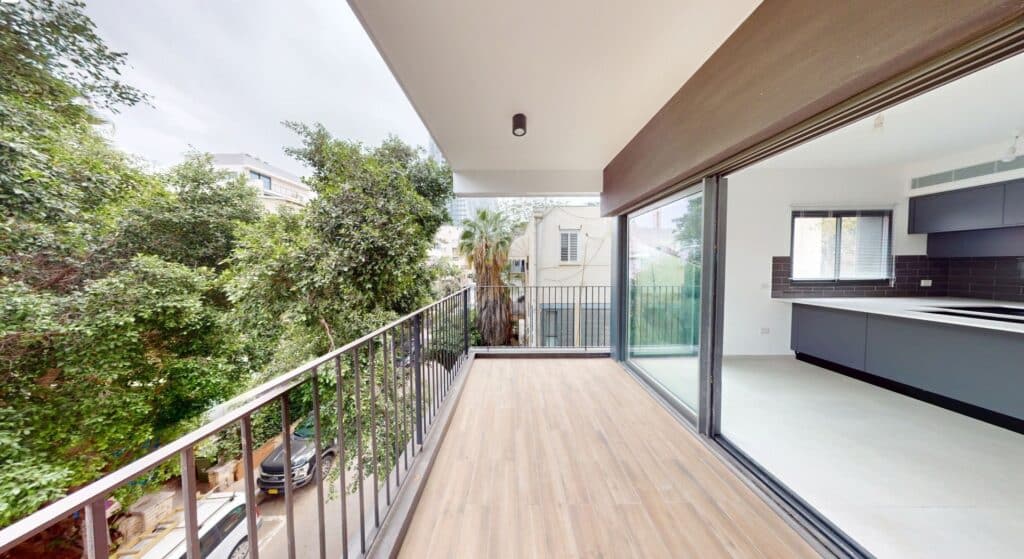 Spacious sun terrace overlooking greenery in Old North Tel Aviv apartment