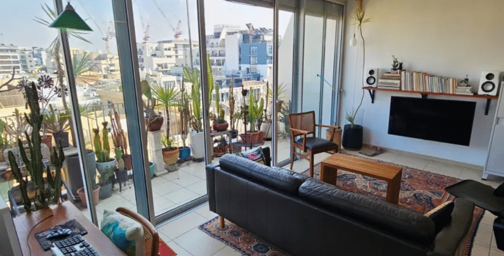 Stylish Tel Aviv living room with glass wall and access to balcony