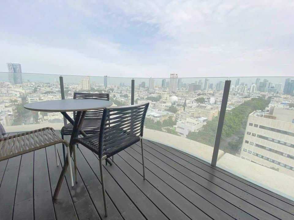 Balcony with glass railing overlooking Tel Aviv skyline