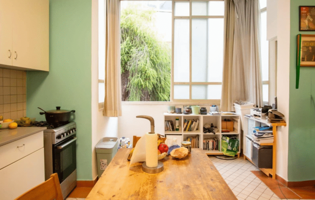 Bright kitchen area with large windows and greenery view