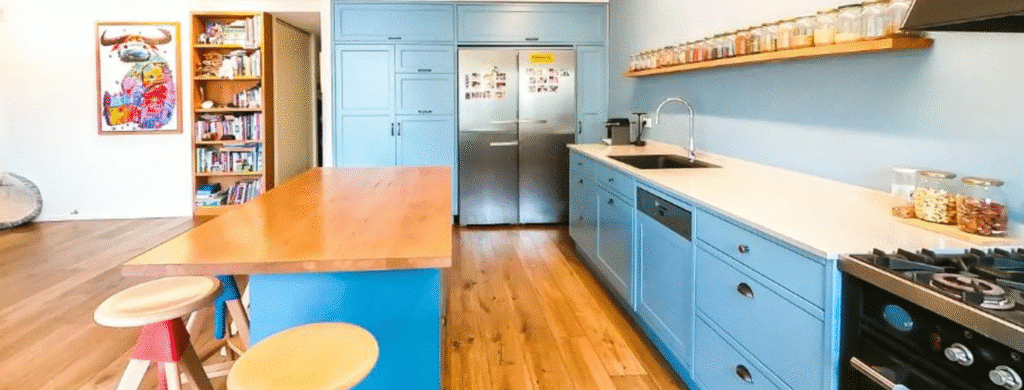 Architect-designed blue kitchen with wooden island in Tel Aviv apartment