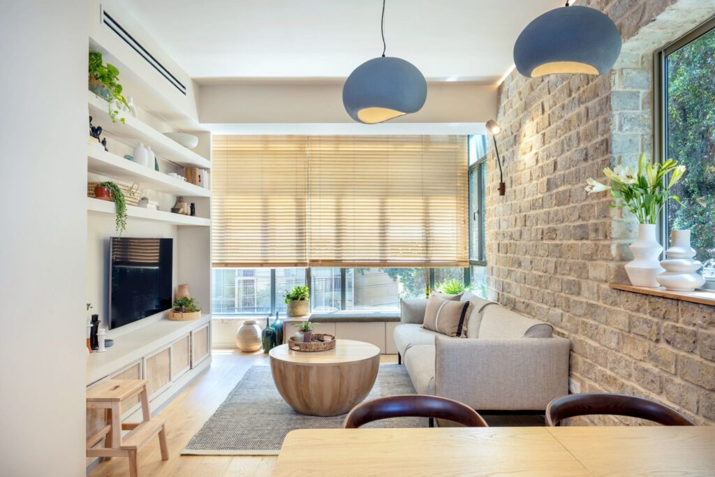 Bright Tel Aviv living room with exposed brick and built-in shelving
