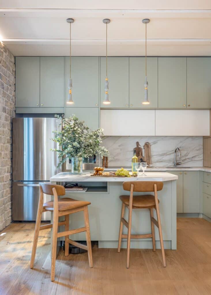 Modern kitchen with marble island and sage cabinets in Tel Aviv rental