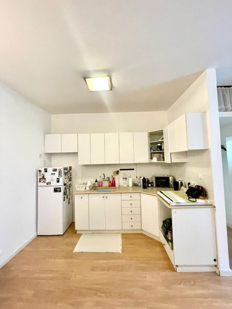 White corner kitchen with built-in storage and appliances