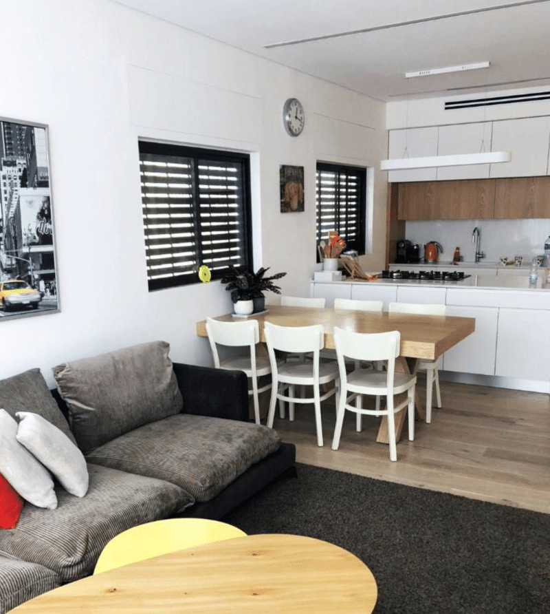 Open-plan living and dining area with modern kitchen in Tel Aviv apartment