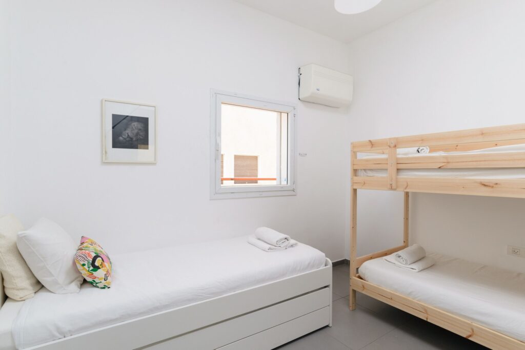 Children's bedroom with bunk and single bed in Tel Aviv apartment