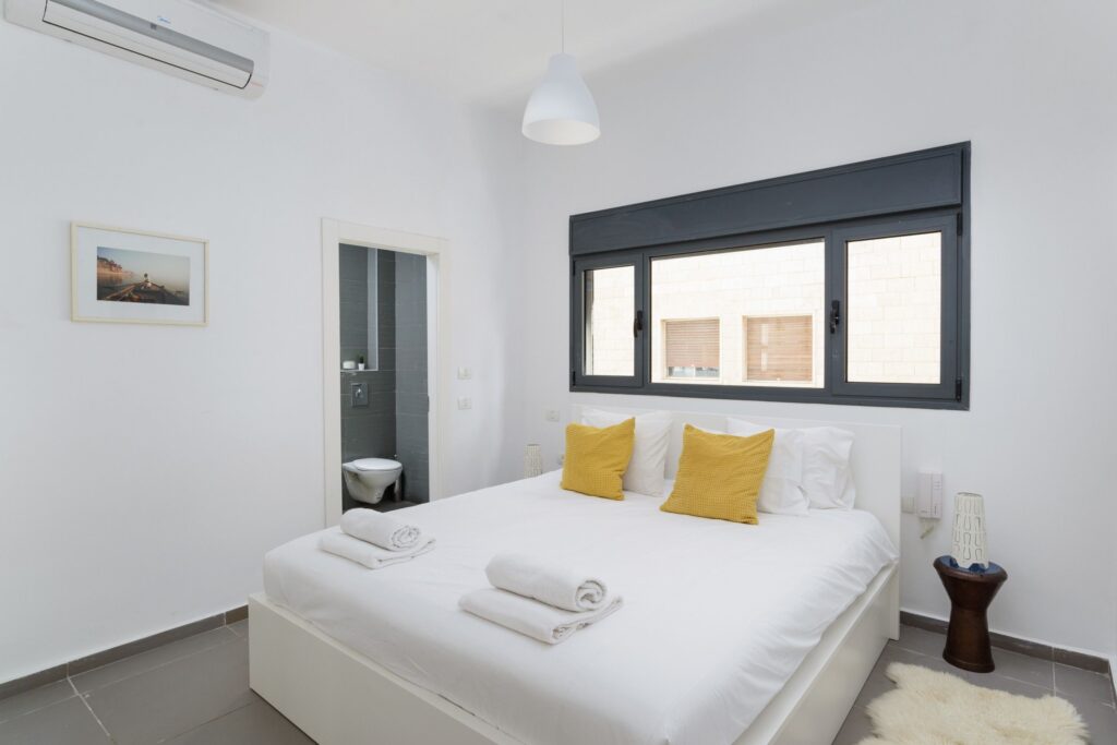 Master bedroom with en-suite bathroom and yellow cushions