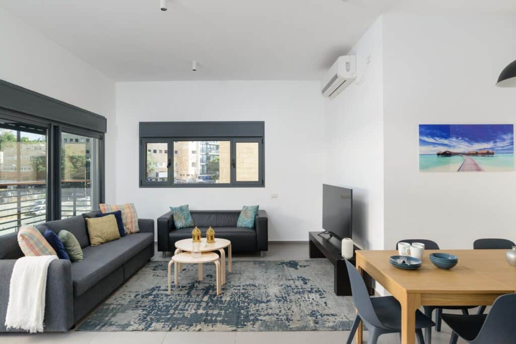 Open-plan living and dining area with large windows and modern furniture