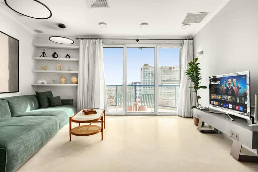 Open-plan living room with sea view and TV in Tel Aviv apartment