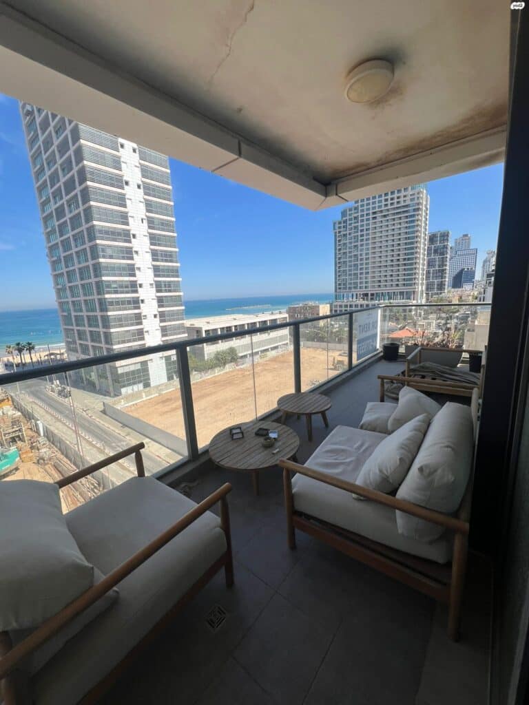 Balcony with outdoor seating and sea view in Tel Aviv