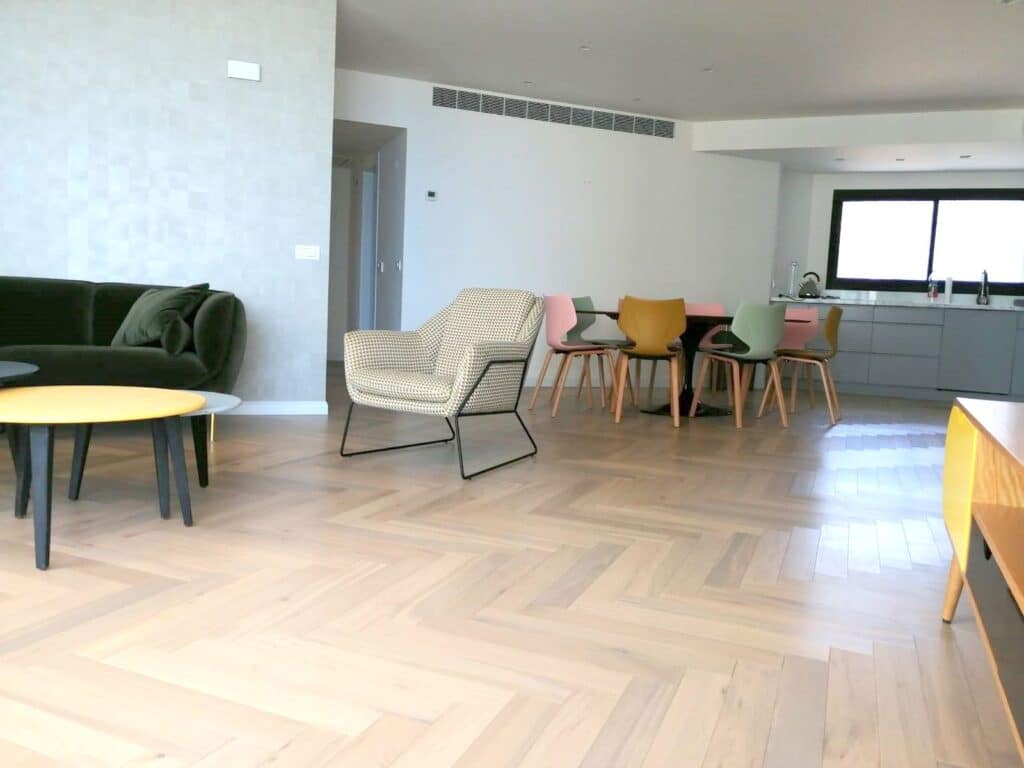 Spacious living and dining area with designer furniture and parquet flooring